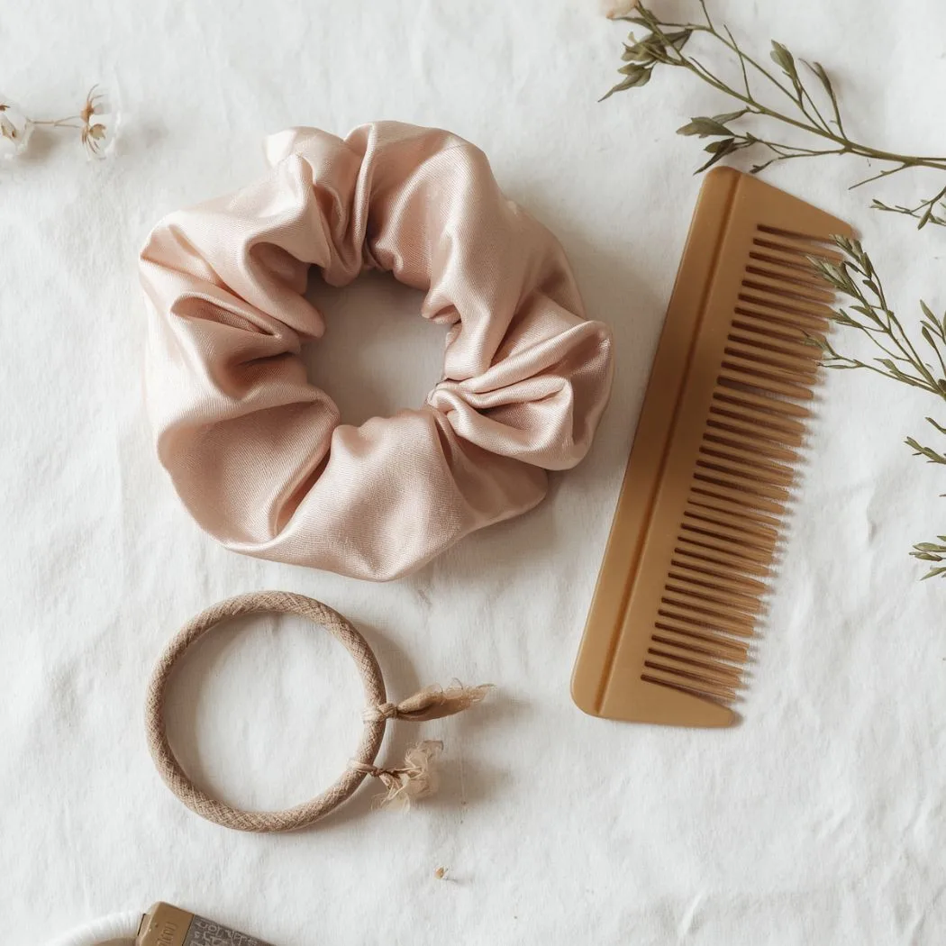 Silk scrunchie and seamless elastics flat lay — gentle hair accessories for workout hairstyles and scalp health