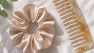 Silk satin scrunchie and wide tooth comb flat lay — gentle gym bag hair essentials for active women