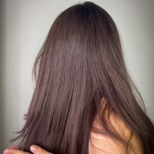 Woman applying leave-in conditioner before running — pre-run hair protection ritual
