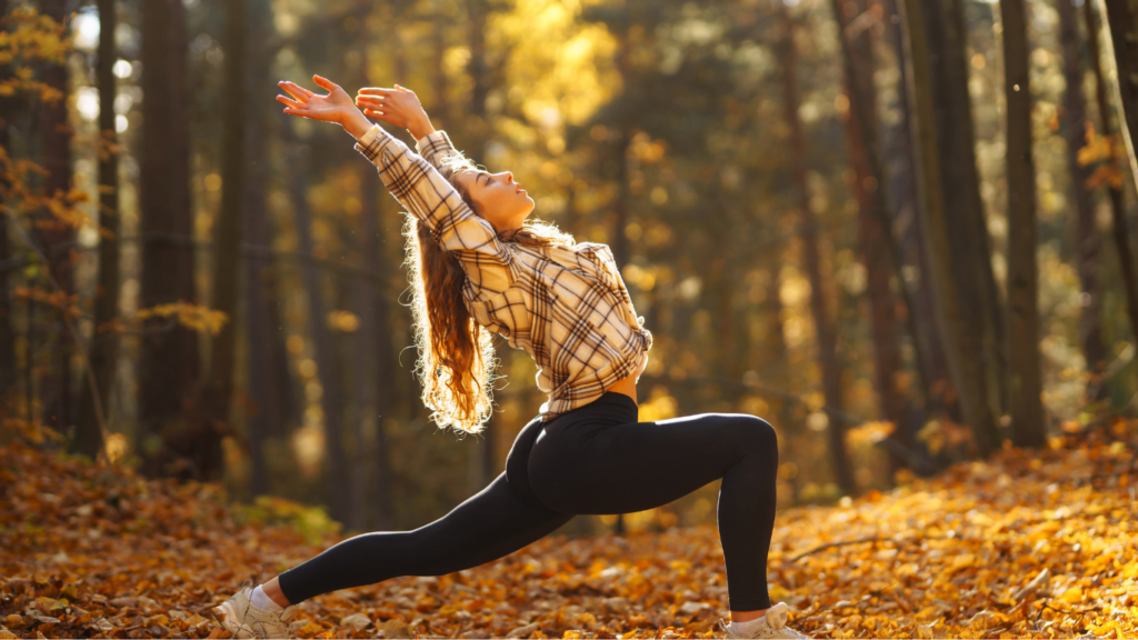 Woman doing yoga stretch outdoors in autumn forest — how fall workouts change your hair and scalp